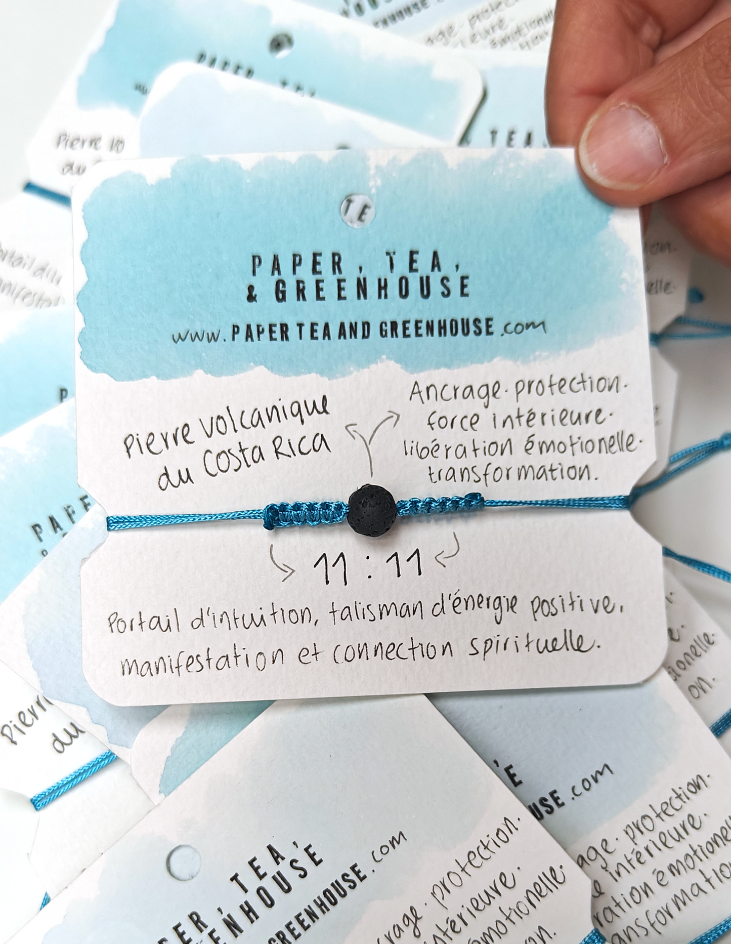 A bracelet with a smooth volcanic stone in the centre, surrounded by turquoise polyester cord knotted by hand with meaning and precision. The spiritual bracelet is in it's packaging, also made by hand where we can find all the meanings.