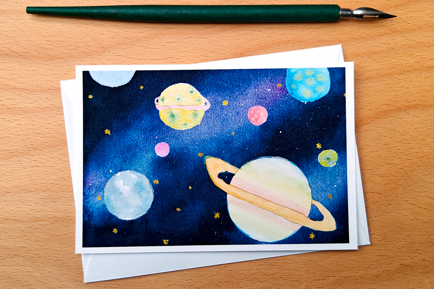 Space-themed greeting card with planets on a wooden surface