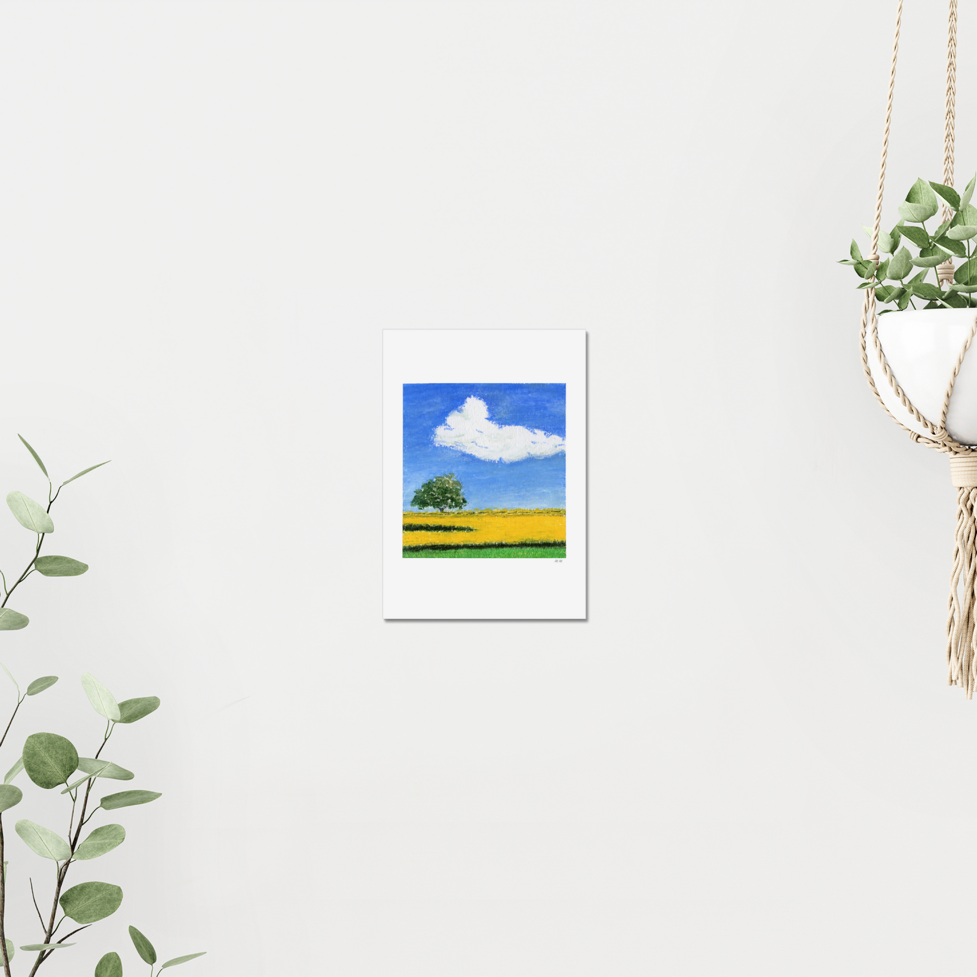 Painting of a tree in a field with a blue sky and white cloud on a white wall surrounded by plants. Made with oil pastels.