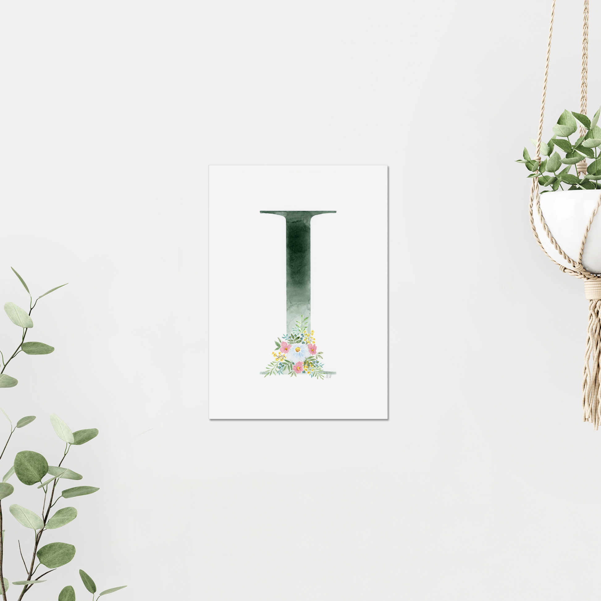 Decorative letter 'I' with floral design on a white background, surrounded by greenery. Made with watercolours.