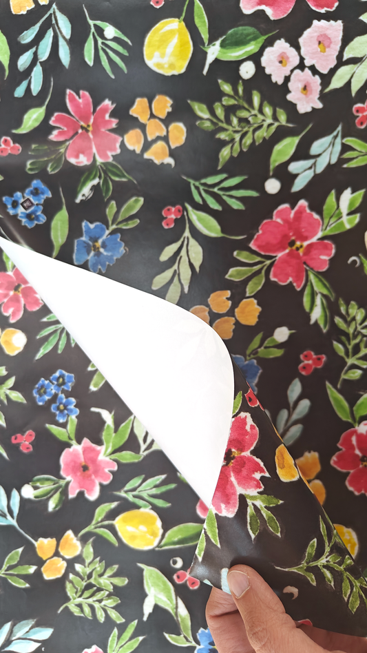 Floral patterned wrapping paper, colourful flowers on a black background. Originally painted in watercolours.