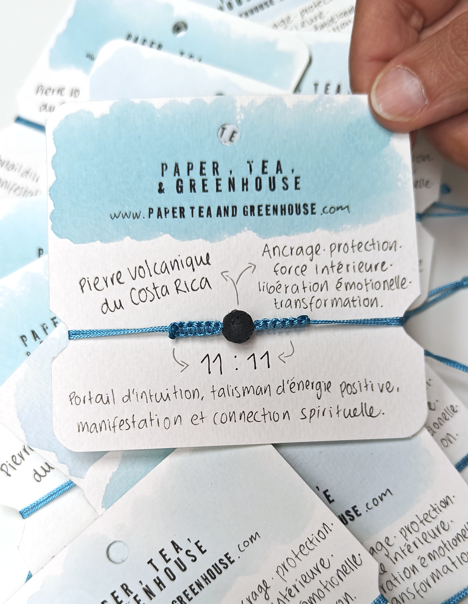 A bracelet with a smooth volcanic stone in the centre, surrounded by turquoise polyester cord knotted by hand with meaning and precision. The spiritual bracelet is in it's packaging, also made by hand where we can find all the meanings.