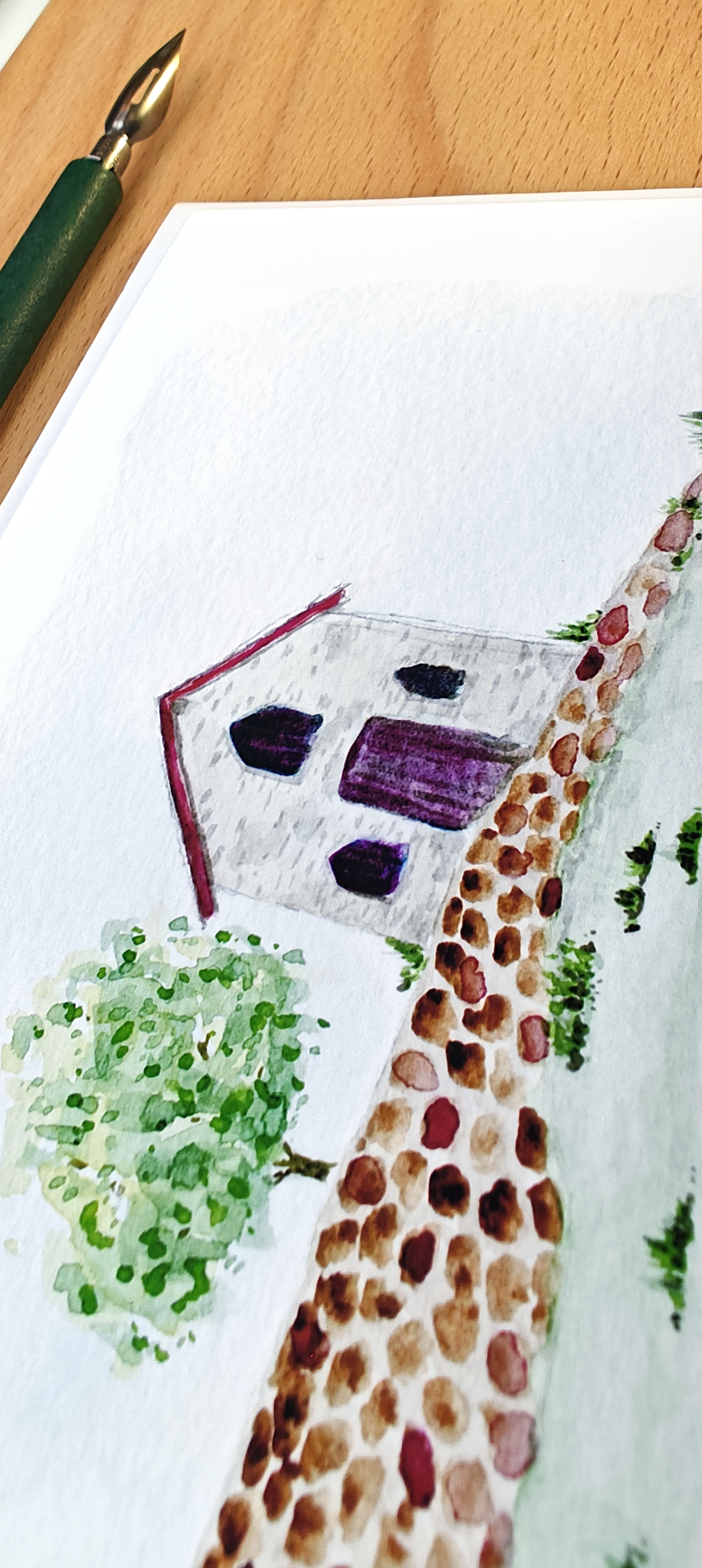 Watercolour of a house with a tree on a white post card.