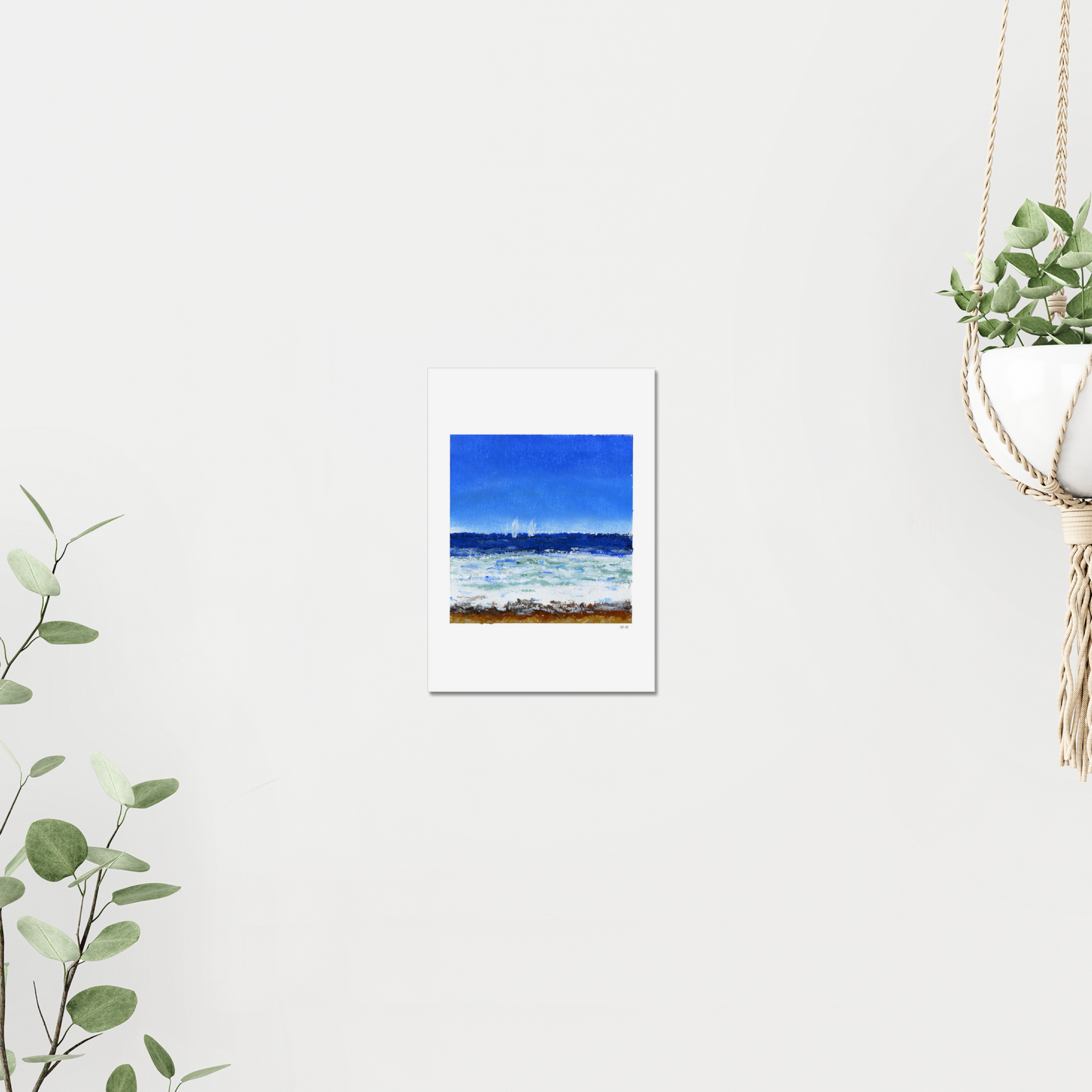 Art print of a coastal scene with blue sky and ocean with waves and sailboats. Made with oil pastels. On a white wall surrounded by plants.