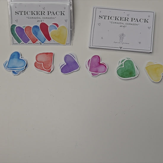 Artist putting together pack of 7 colourful, heart-shapped stickers