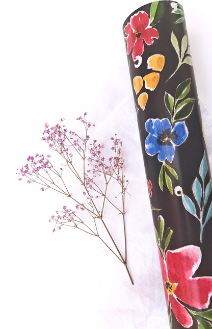 Floral-patterned wrapping paper on a white background with dried flowers.